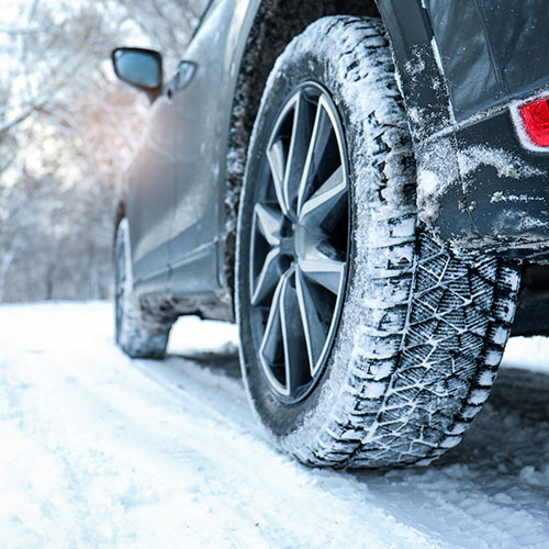 Winter Car Tire on Snowy Road