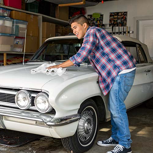 A man cleans a classic car