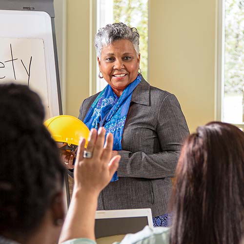 A woman presents on safety to an audience of workers