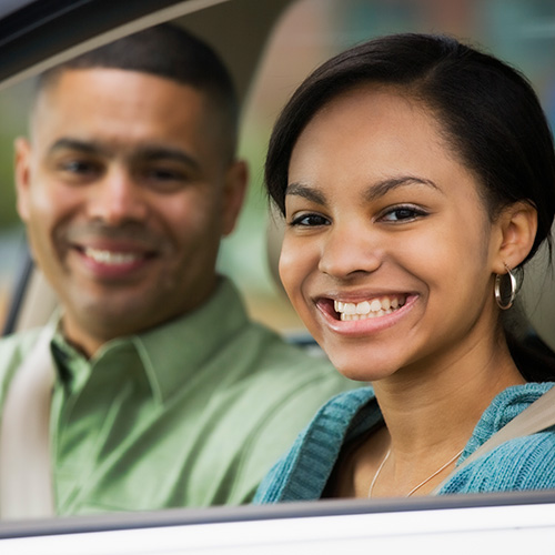 A teenager and driving instructor in a car