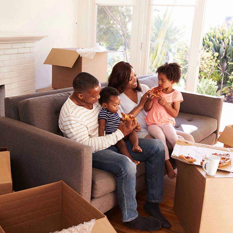 A family eats lunch while unpacking