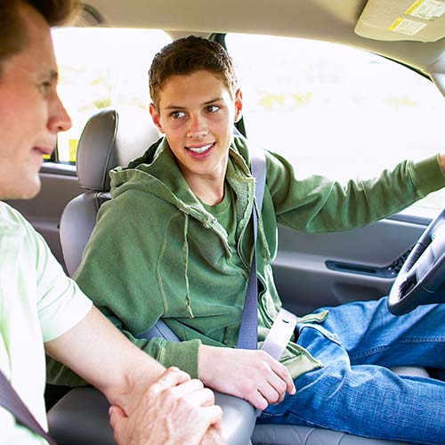 A teen driver practices with his parent